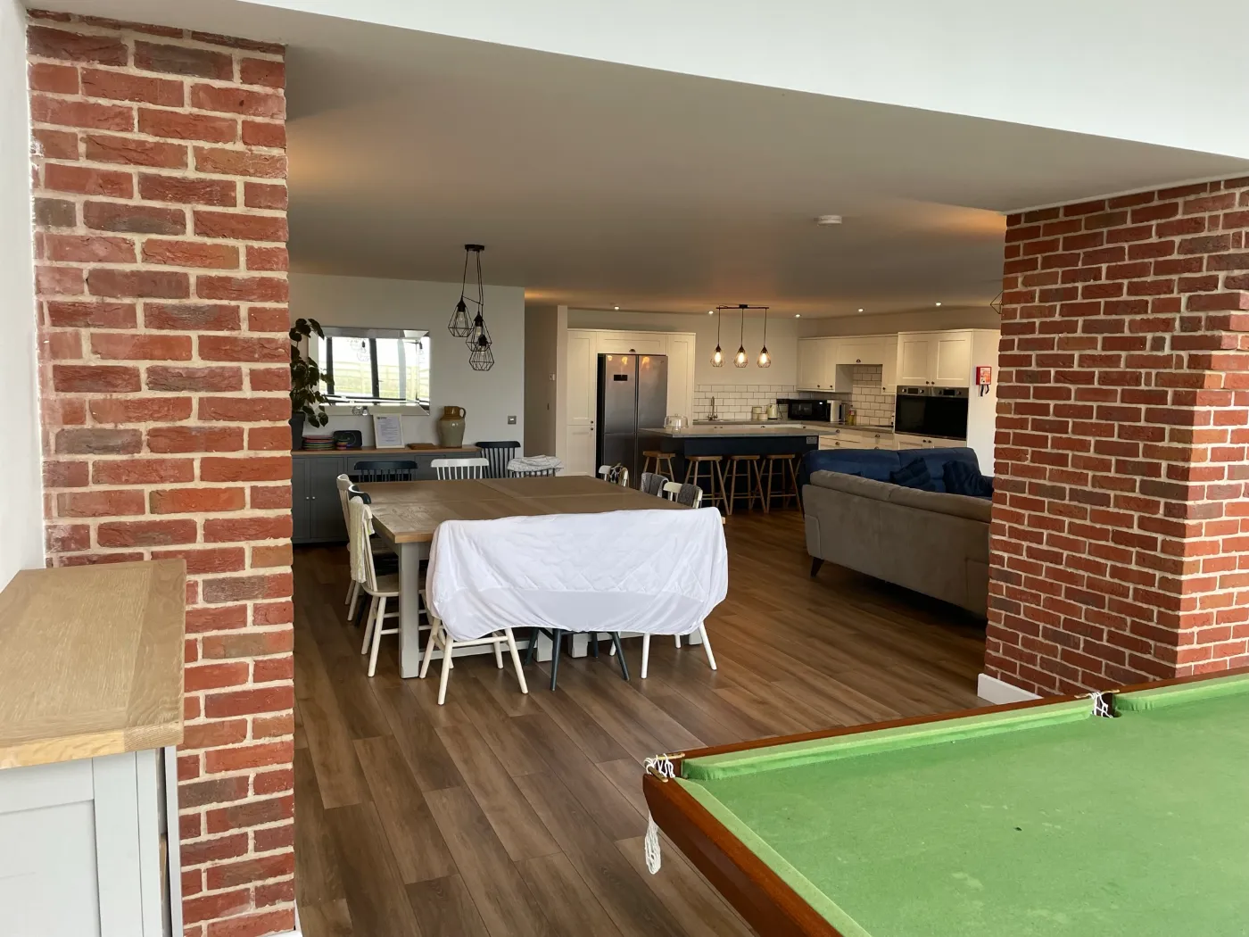 Open-plan barn conversion kitchen and dining room by Stellar Construction